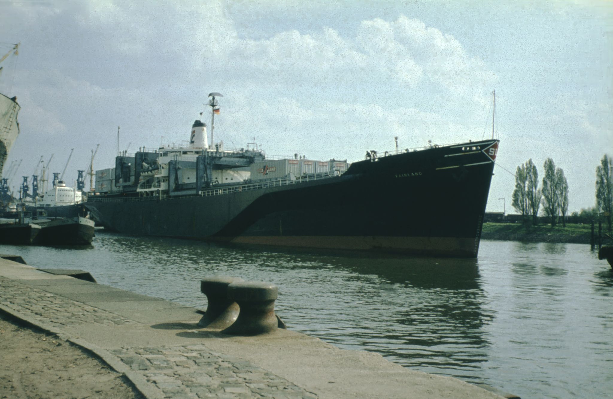 Das Sea-Land-Containerschiff Fairland 1966 im Bremer Überseehafen, an Deck gestapelte Sea-Land-Container, im Hintergrund die Hafenkräne am Kai.